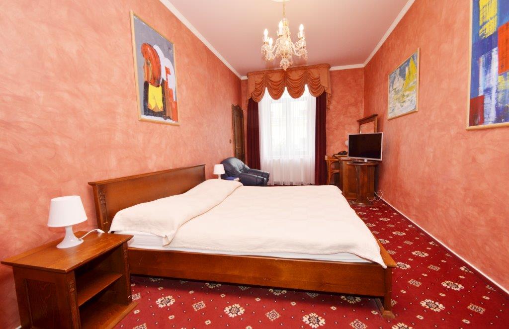 Deluxe Room — Pohled na postel a pracovní kout s LED televizorem